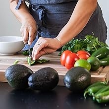 Chef chopping up jalapenos on acacia wood cutting board