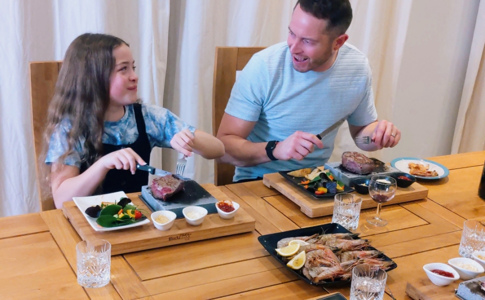 family steak stone home cooking meal on a sizzling hot cooking grill stone